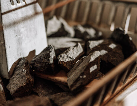 A close-up of dark stones and a metal spatula in a drying rack or tray.