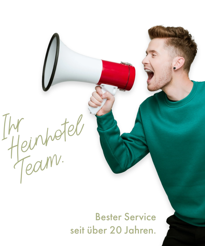 Mann in grünem Pullover ruft in ein Megaphon mit deutschem Text über Hotelservice und Team.